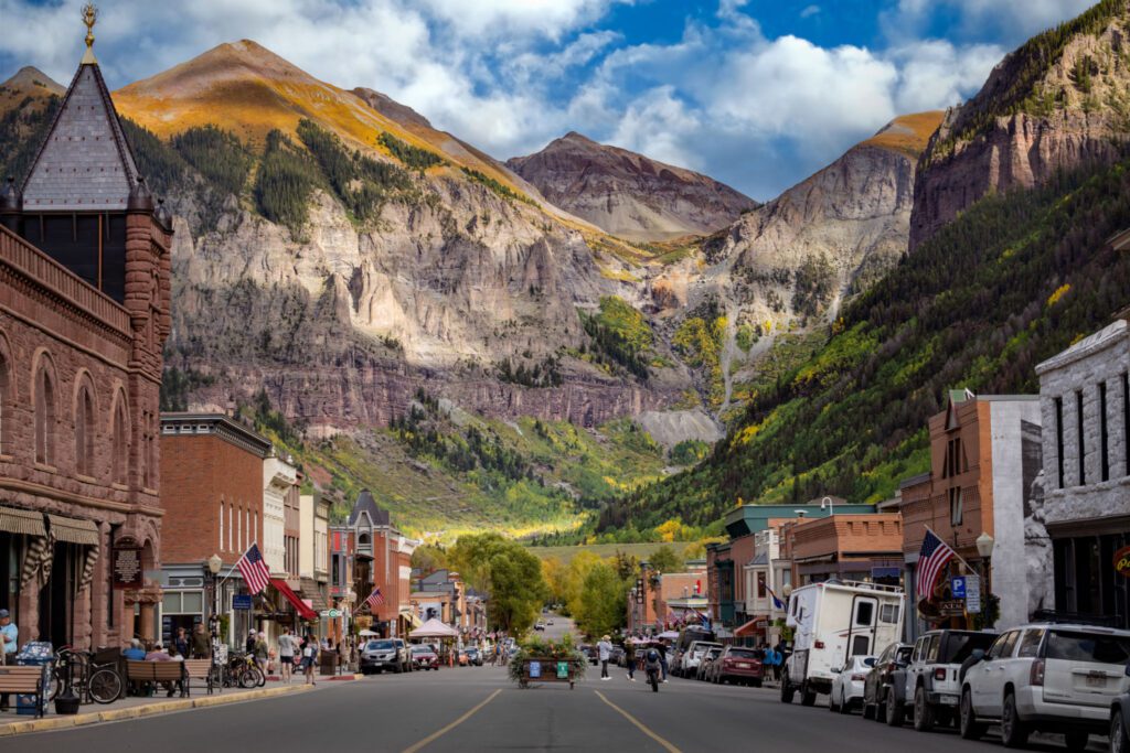 Mountain town street with scenic mountain background.